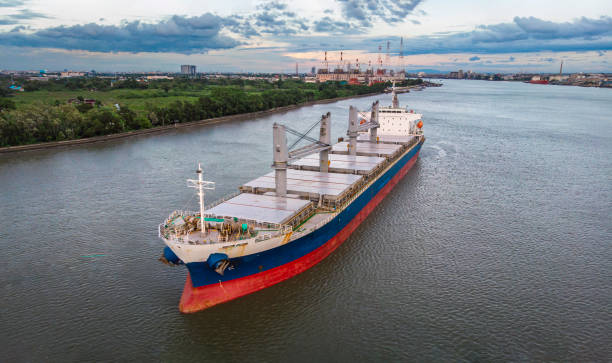 Aerial view/A large bulk ship parked in the river waiting to load the cargo.