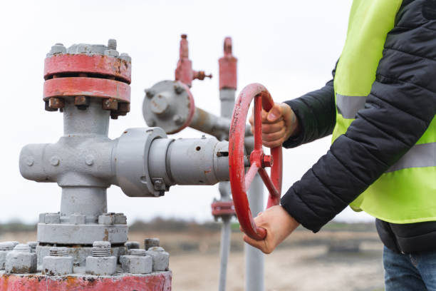 All is under control. Pipeline equipment. Resource  transportation. Worker pumping down lines on the Gas drilling pad site. Disconnection or connection of gas or oil